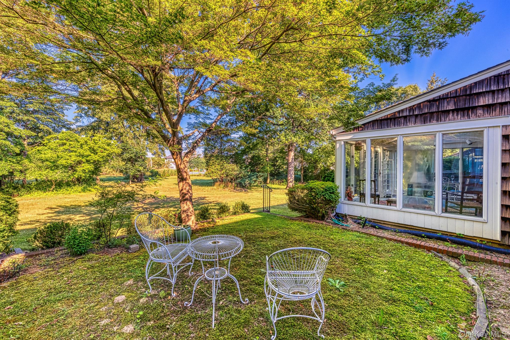 272 Ocean Avenue Islip, NY 11751 - Photo 33 of 39 a view of a patio with table and chairs and potted plants with large tree