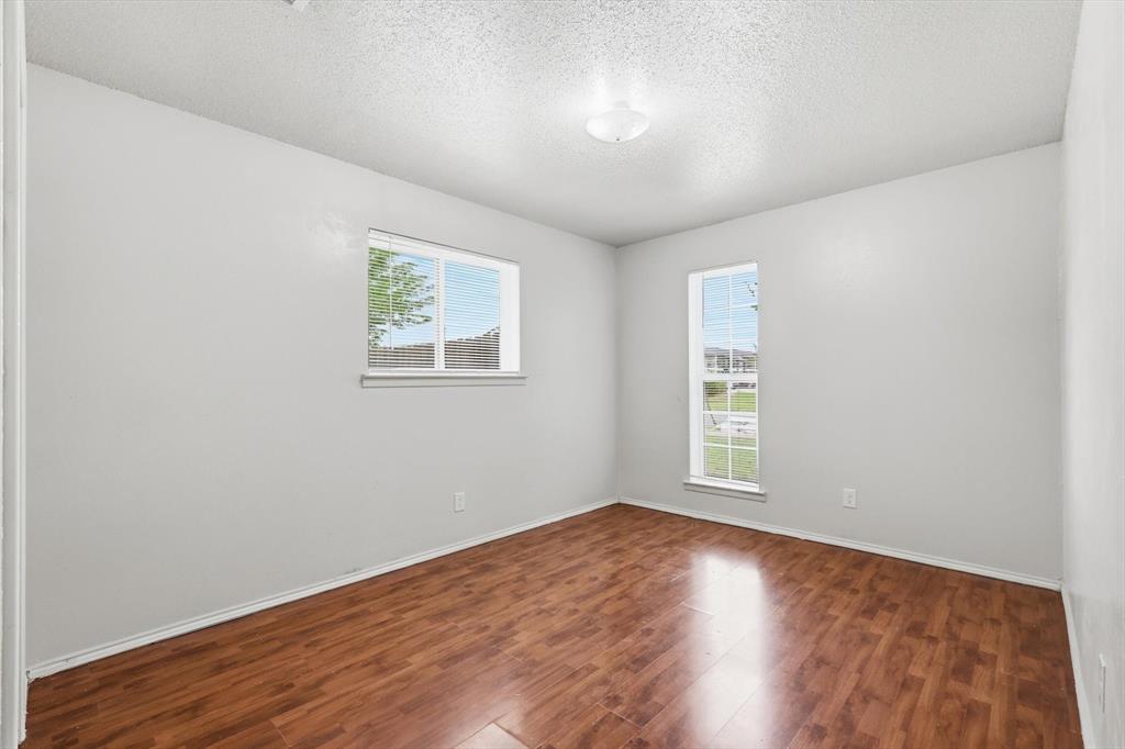 756 East Pecan Street Hurst, TX 76053 - Photo 17 of 19 an empty room with wooden floor and windows