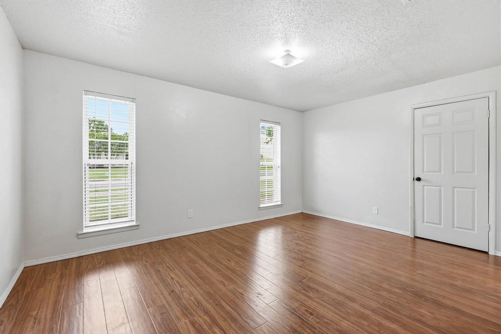 756 East Pecan Street Hurst, TX 76053 - Photo 5 of 19 an empty room with wooden floor and windows