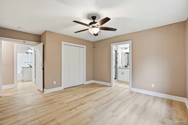 a view of empty room with wooden floor and ceiling fan