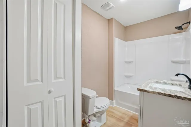 a bathroom with a granite countertop sink a toilet and a shower