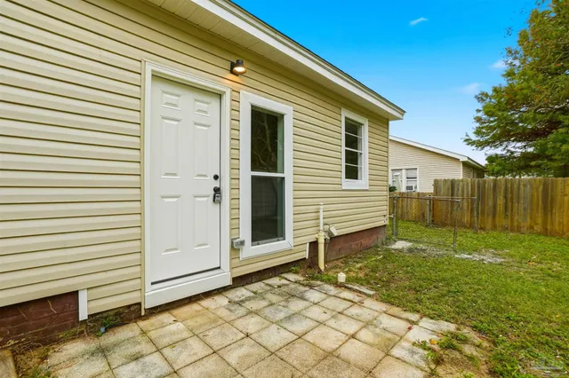 a view of a house with backyard and wooden fence
