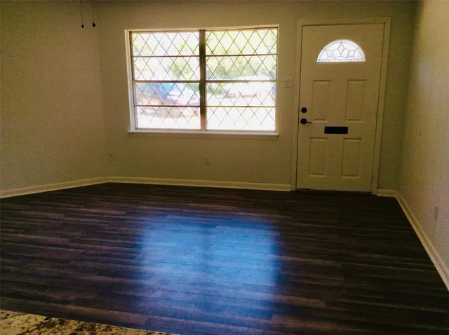 wooden floor in an empty room with a window