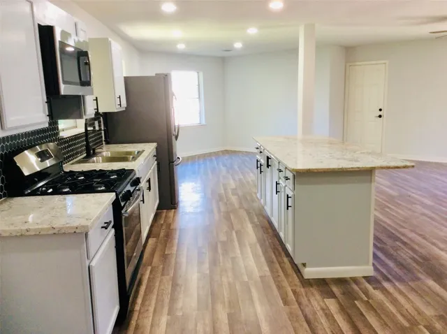 a kitchen with a sink stove and cabinets