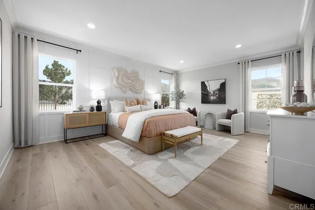 a bedroom with a bed couch mirror and a window