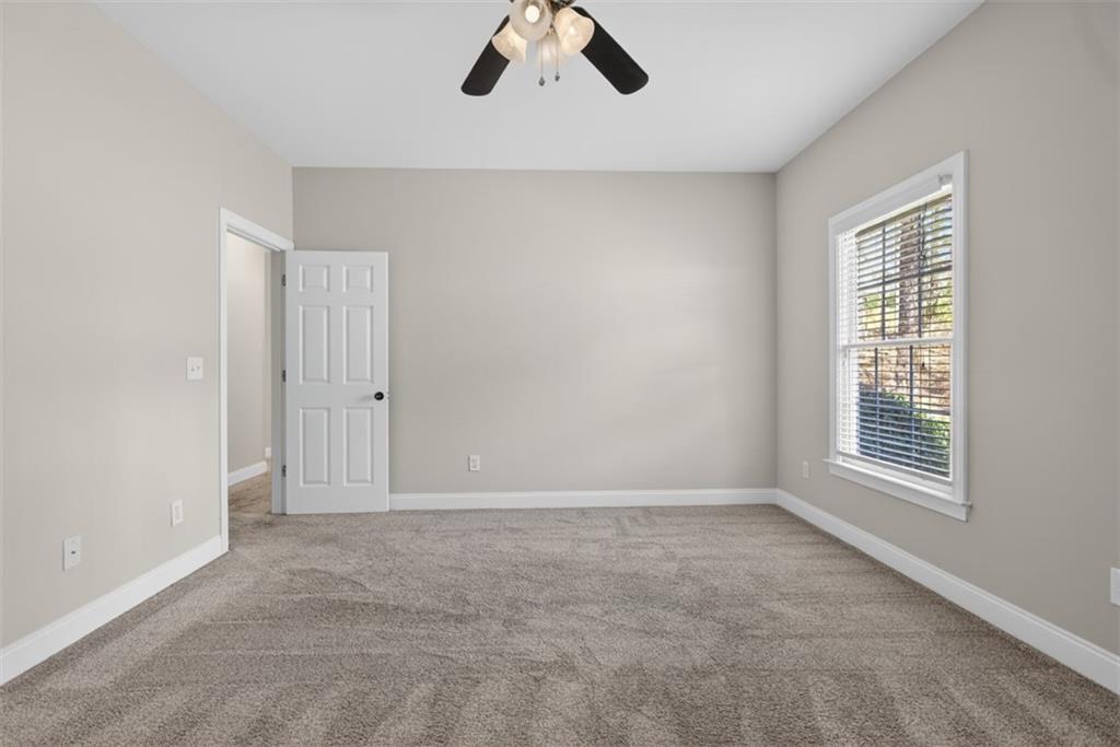 3570 Bulloch Lake Road Loganville, GA 30052 - Photo 41 of 71 an empty room with chandelier fan and windows