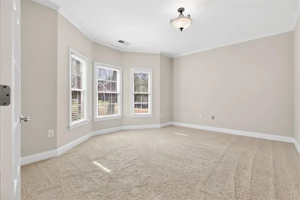a view of an empty room with a fireplace and a ceiling fan