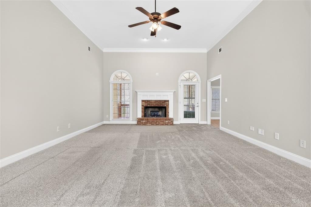 3570 Bulloch Lake Road Loganville, GA 30052 - Photo 9 of 71 a view of an empty room with a fireplace and a ceiling fan