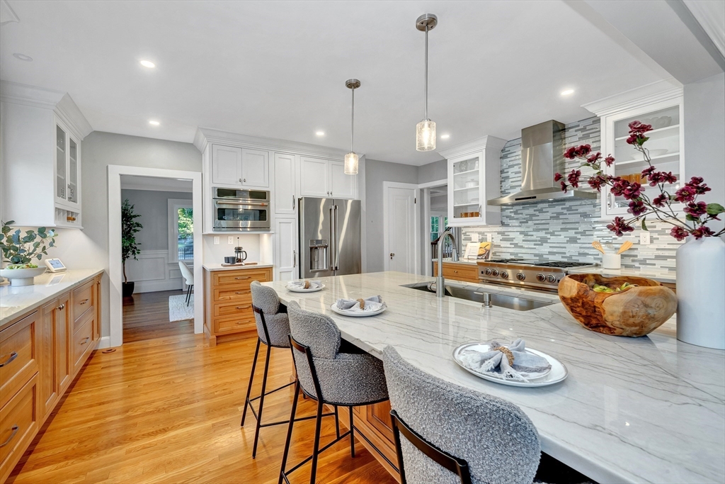 58 Bacon Street Winchester, MA 01890 - Photo 14 of 40 a kitchen with stainless steel appliances granite countertop a stove a kitchen island a table and chairs