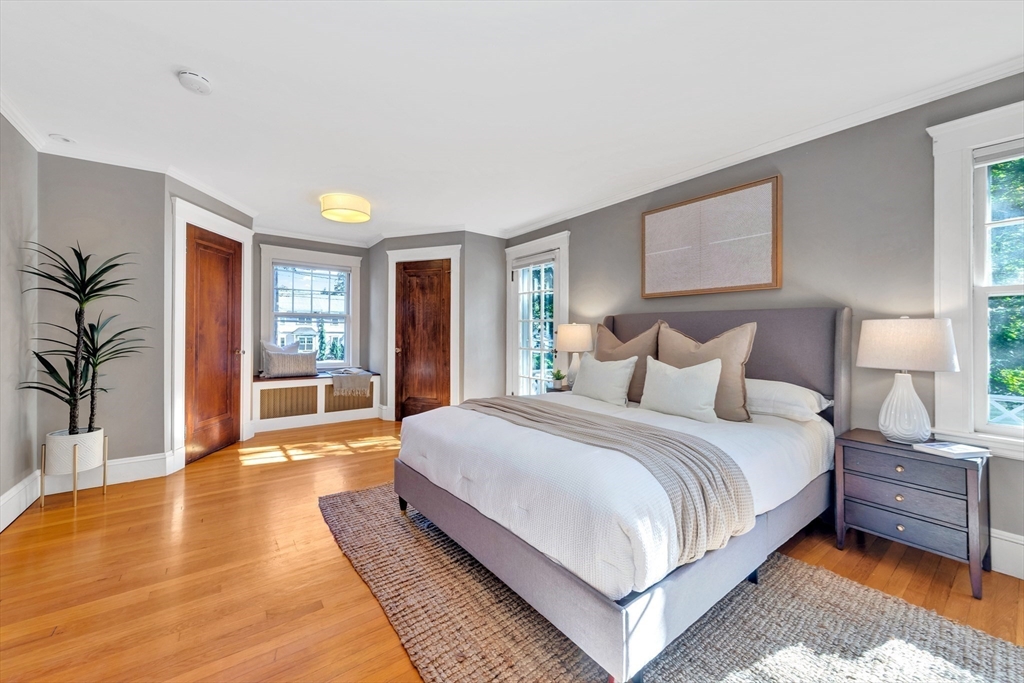 58 Bacon Street Winchester, MA 01890 - Photo 21 of 40 a large bedroom with a bed wooden floor and table