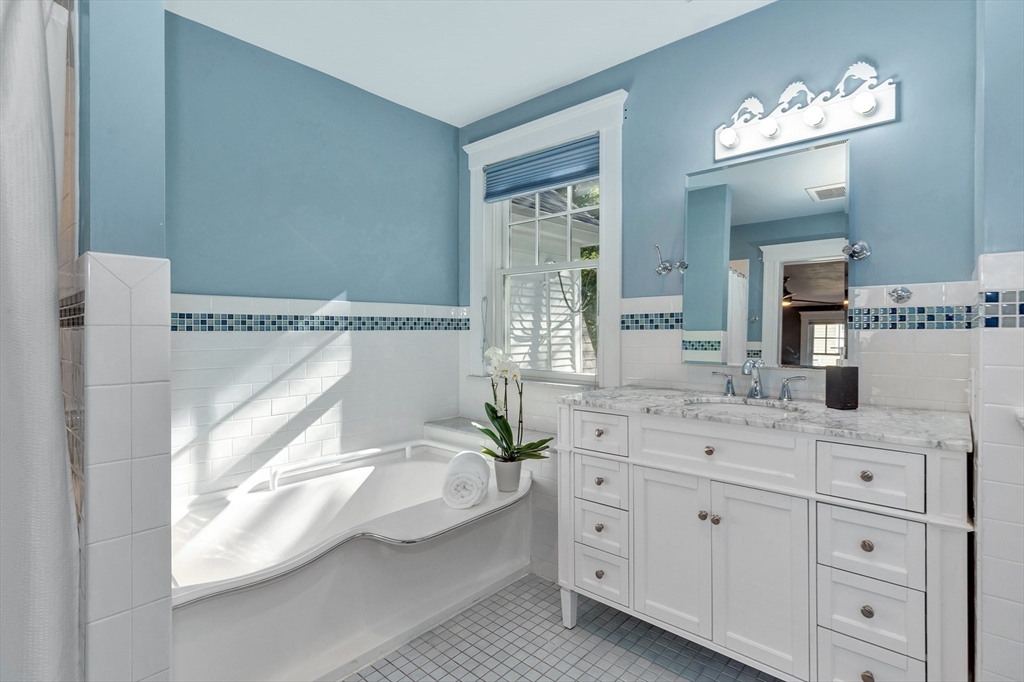 58 Bacon Street Winchester, MA 01890 - Photo 29 of 40 a spacious bathroom with a double vanity sink a mirror a bathtub and