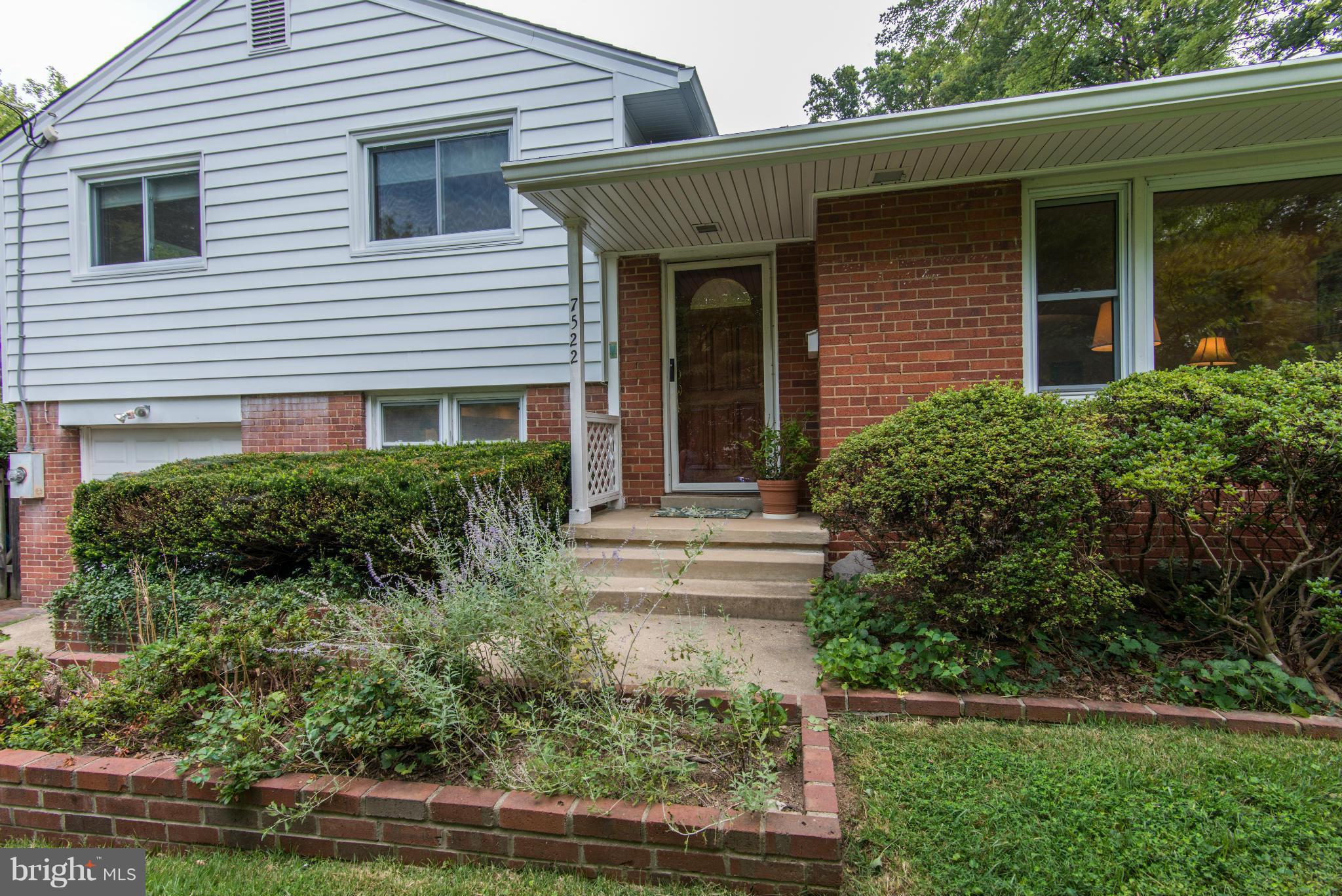 7522 Havelock Street Springfield, VA 22150 - Photo 3 of 30 a view of brick house with a yard plants and large tree