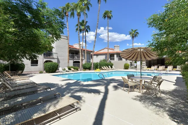 a view of a patio with a table and chairs under an umbrella