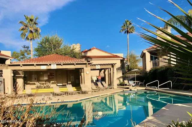 a view of a house with pool and chairs