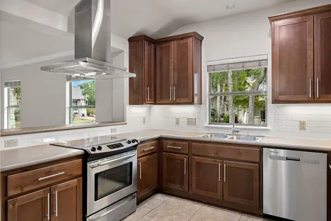 a kitchen with stainless steel appliances granite countertop wooden cabinets a sink and dishwasher a refrigerator with wooden cabinets