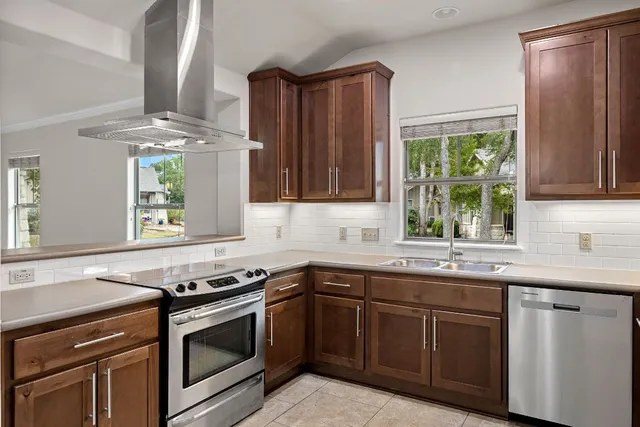 a kitchen with stainless steel appliances granite countertop a sink stove and cabinets