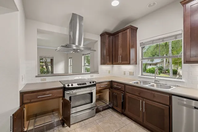 a kitchen with stainless steel appliances a stove sink and cabinets