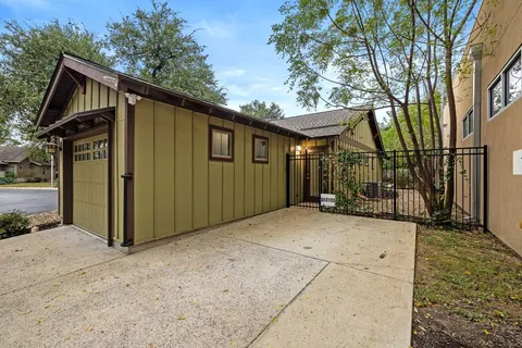 a view of a blue house with a big yard and large trees