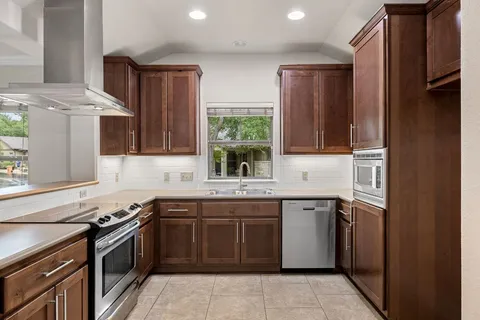 a kitchen with a sink stove and cabinets
