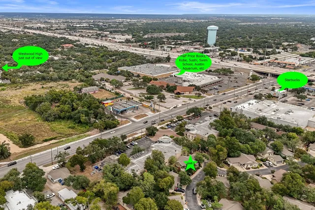 an aerial view of a houses with a yard and lake view
