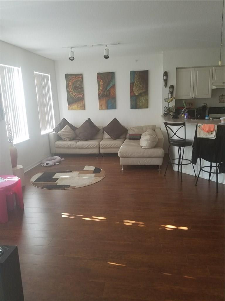 6498 West Sample Road, Unit 6498 Coral Springs, FL 33067 - Photo 5 of 19 a living room with furniture and a kitchen