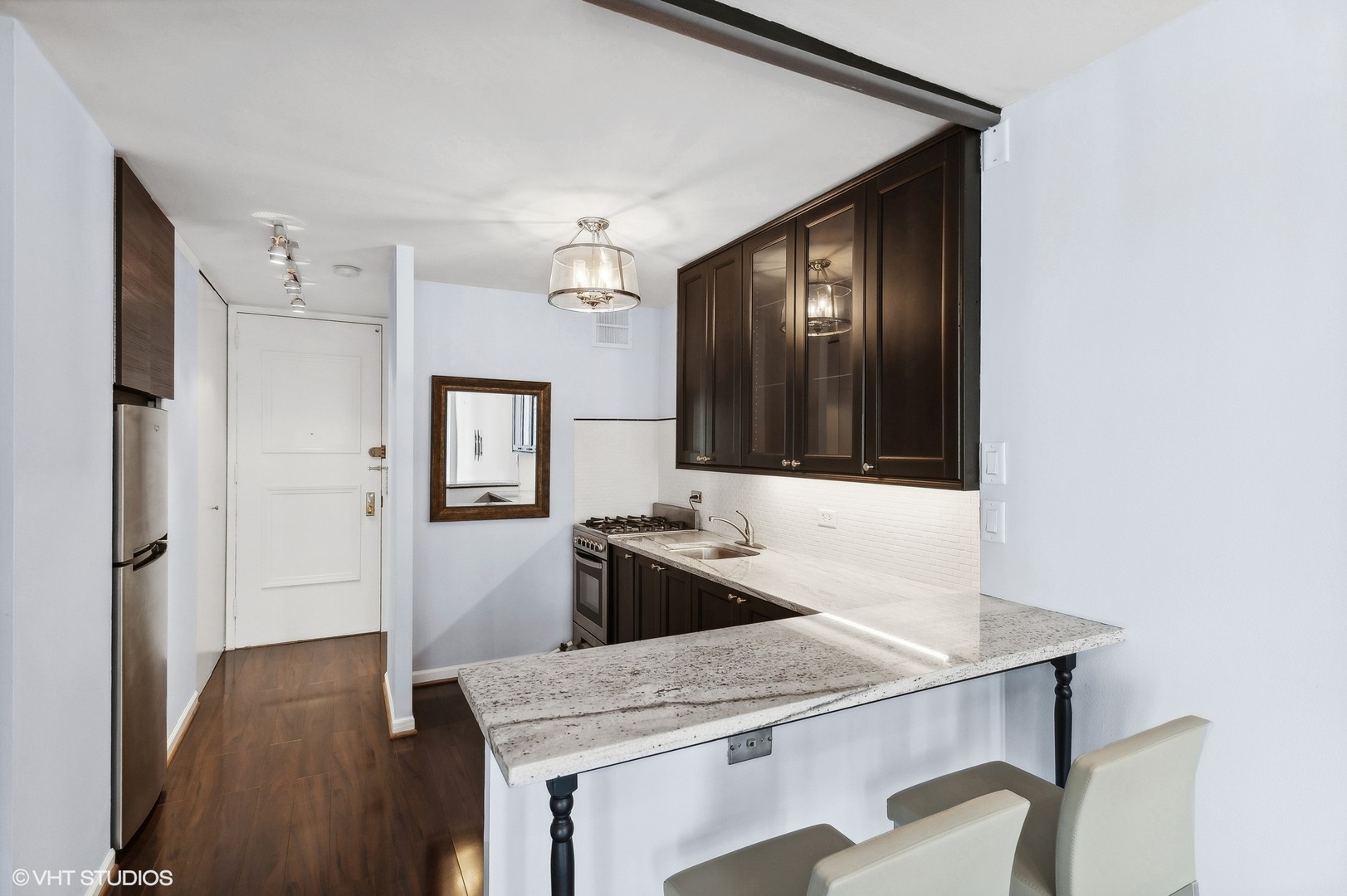 1 East Scott Street, Unit 1006 Chicago, IL 60610 - Photo 6 of 15 a kitchen with a table and chairs