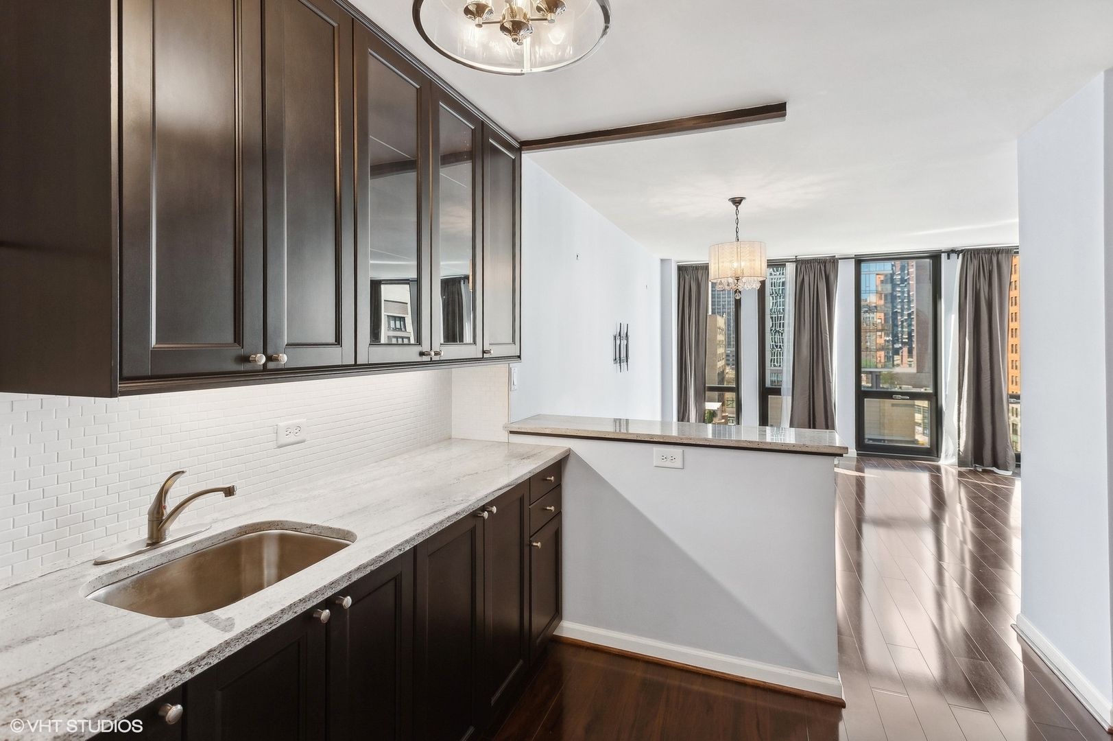 1 East Scott Street, Unit 1006 Chicago, IL 60610 - Photo 10 of 15 a kitchen with stainless steel appliances granite countertop a sink and a refrigerator with wooden floor