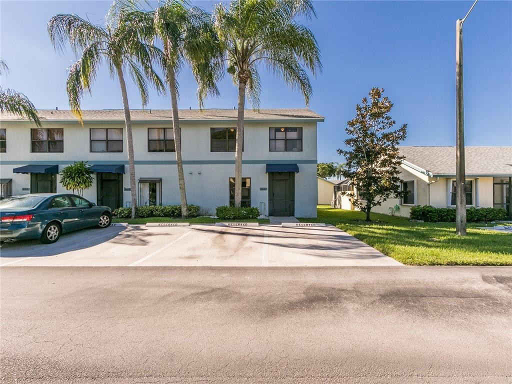 9112 Southwest 21st Court, Unit F Boca Raton, FL 33428 - Photo 1 of 34 a view of a house with a yard and palm trees