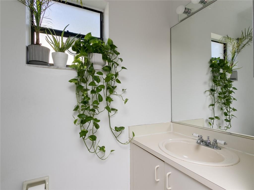9112 Southwest 21st Court, Unit F Boca Raton, FL 33428 - Photo 14 of 34 a bathroom with a sink a mirror and a potted plant