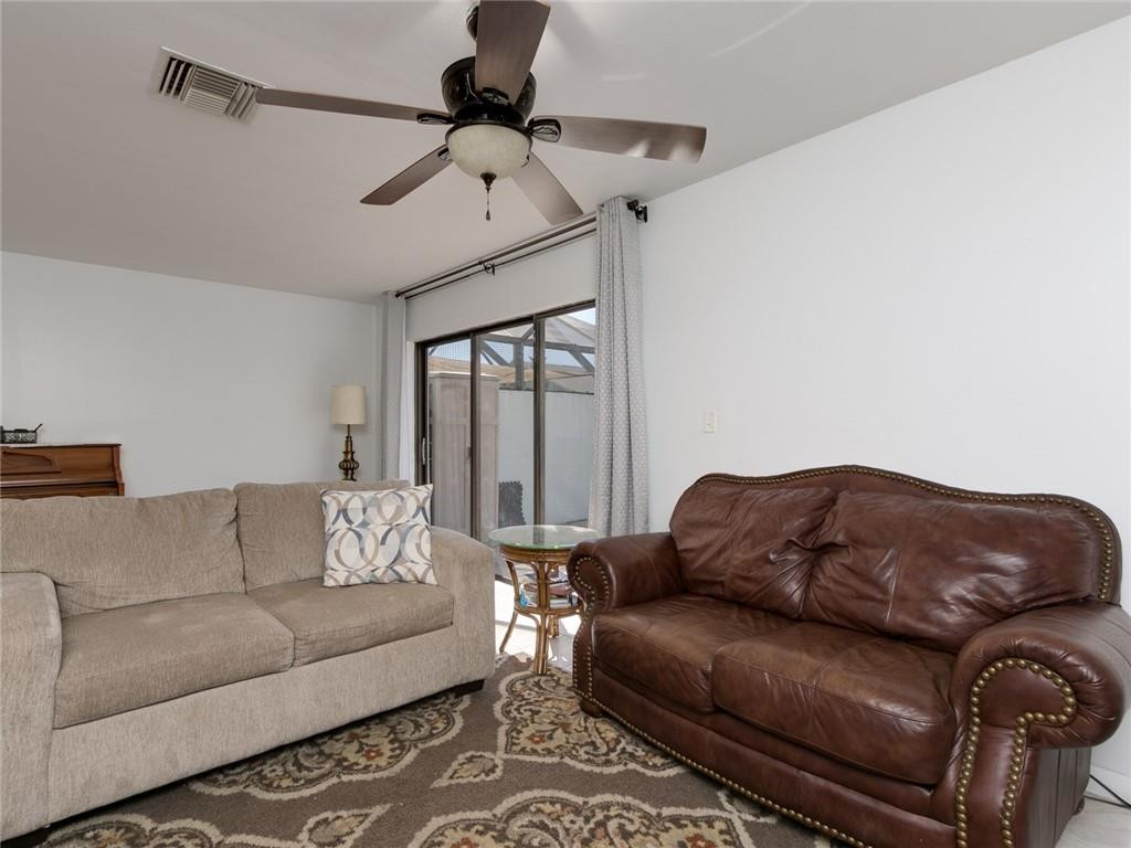 9112 Southwest 21st Court, Unit F Boca Raton, FL 33428 - Photo 16 of 34 a living room with furniture a ceiling fan and a rug