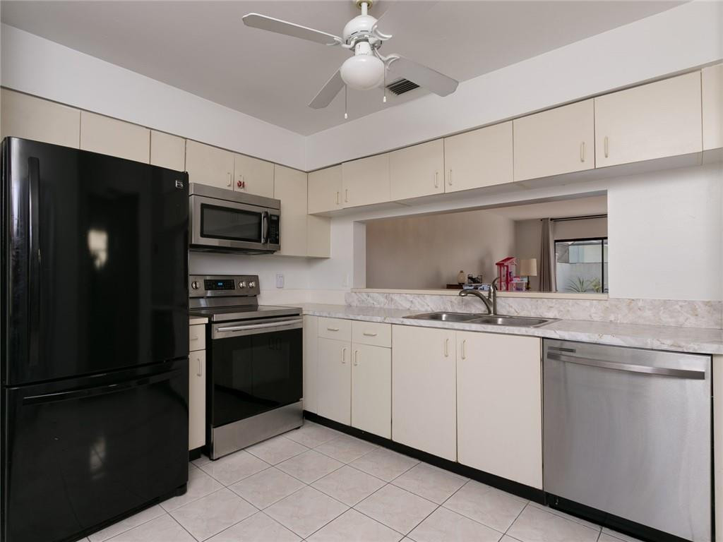 9112 Southwest 21st Court, Unit F Boca Raton, FL 33428 - Photo 2 of 34 a kitchen with stainless steel appliances granite countertop a refrigerator and a sink