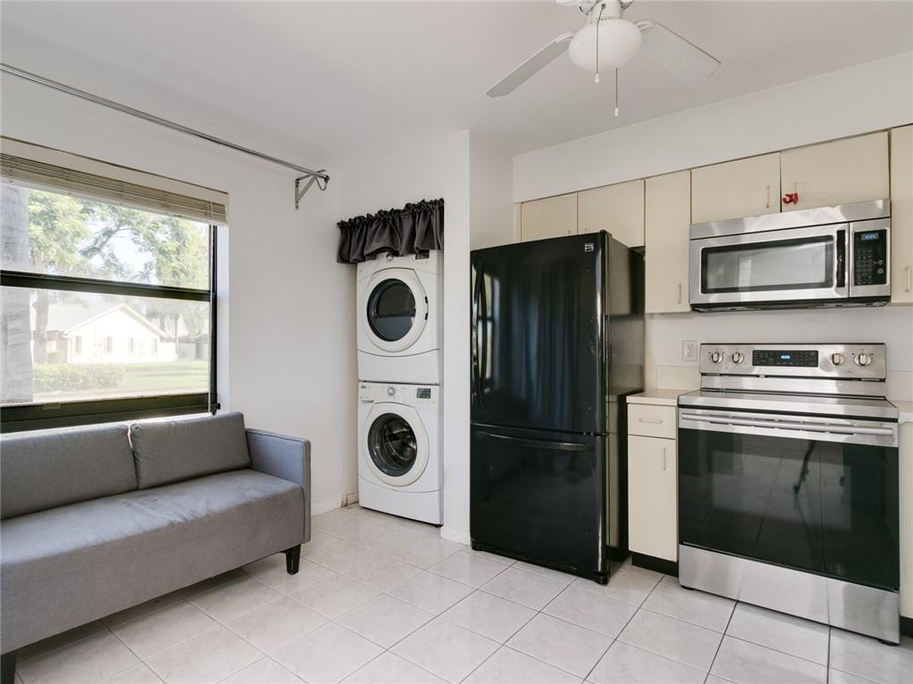 9112 Southwest 21st Court, Unit F Boca Raton, FL 33428 - Photo 3 of 34 a kitchen with a refrigerator and washer