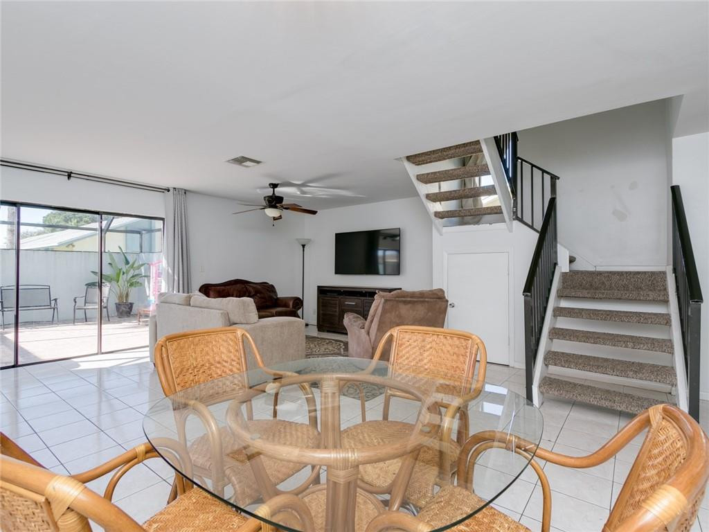 9112 Southwest 21st Court, Unit F Boca Raton, FL 33428 - Photo 5 of 34 a living room with furniture a flat screen tv and a floor to ceiling window