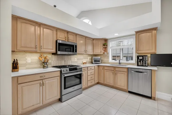a kitchen with white cabinets sink and stainless steel appliances