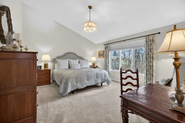 a bedroom with a bed table and a flat screen tv