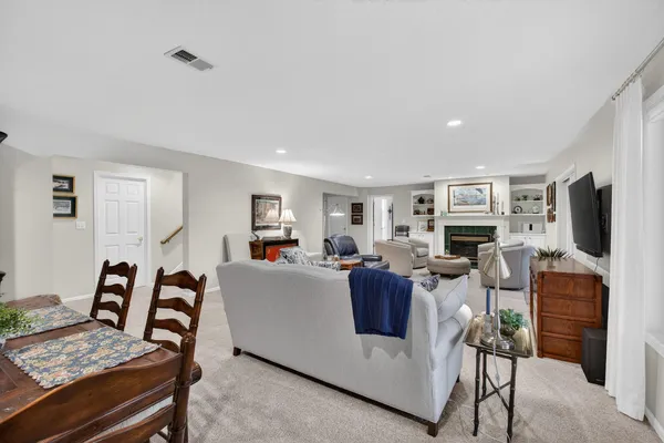 a living room with furniture a flat screen tv and a dining table
