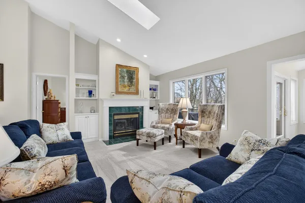 a living room with furniture fireplace and a large window