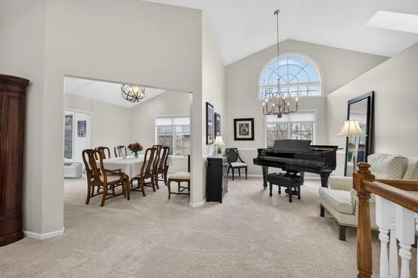 a view of a dining room with furniture a chandelier and a window
