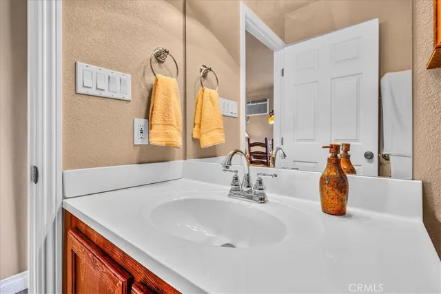 a bedroom with a bed and dresser with wooden floor