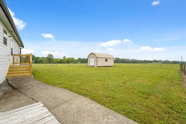 a view of a small house with backyard