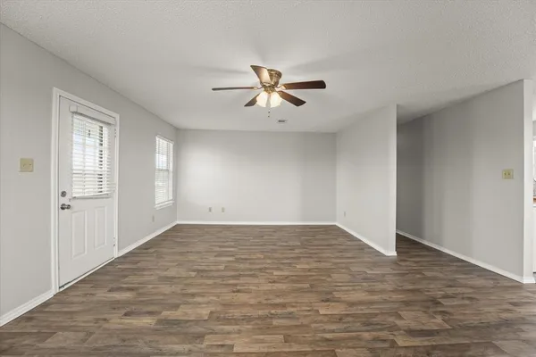 an empty room with fan and windows