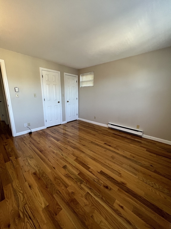 21 Bessom Street, Unit 6 Marblehead, MA 01945 - Photo 11 of 12 an empty room with wooden floor