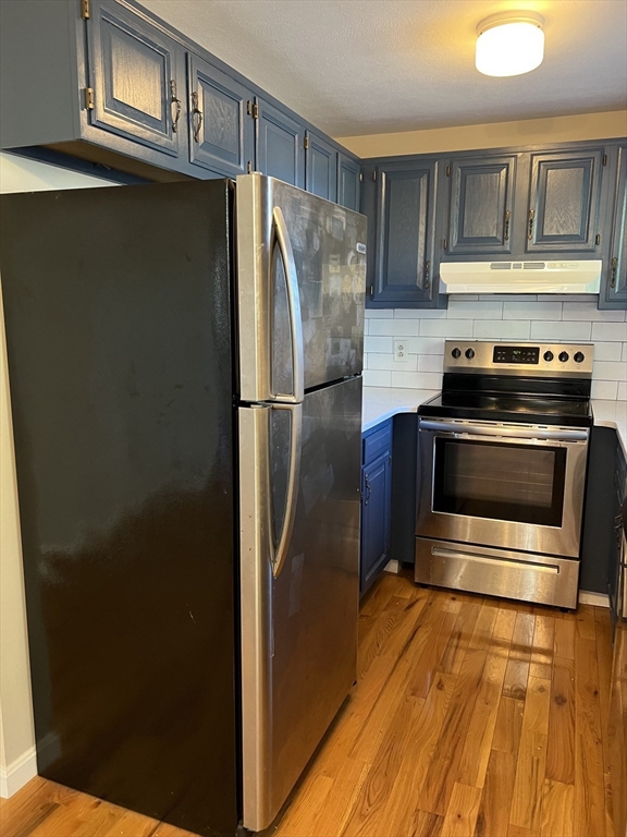 21 Bessom Street, Unit 6 Marblehead, MA 01945 - Photo 3 of 12 a metallic refrigerator freezer sitting in a kitchen