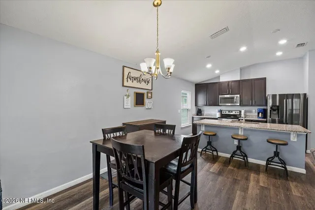 a view of a dining room with furniture wooden floor and a chandelier