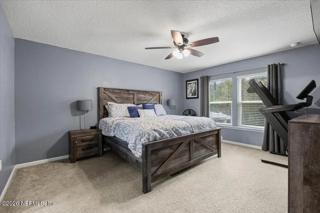 a bedroom with a bed flat screen tv and a large window