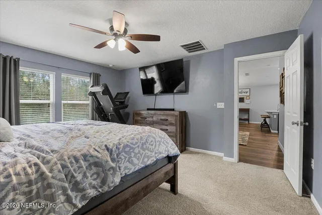 a bedroom with a large bed a flat tv screen and a walk in closet