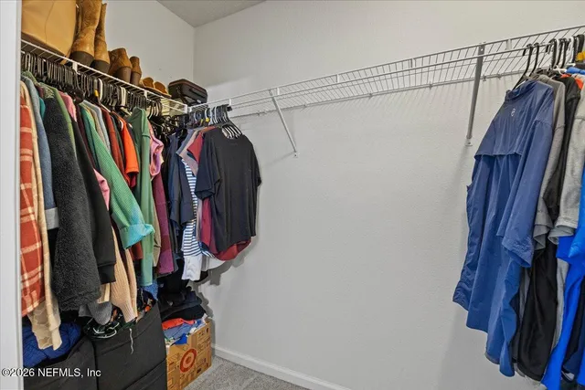 a view of walk in closet with clothes
