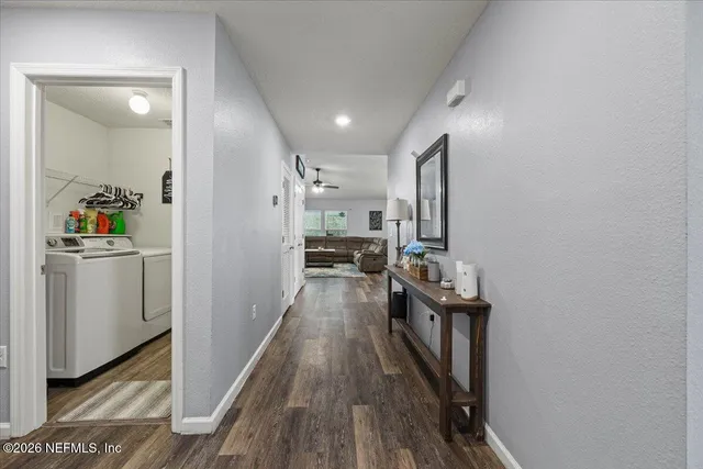 a view of a hallway to a livingroom and a kitchen
