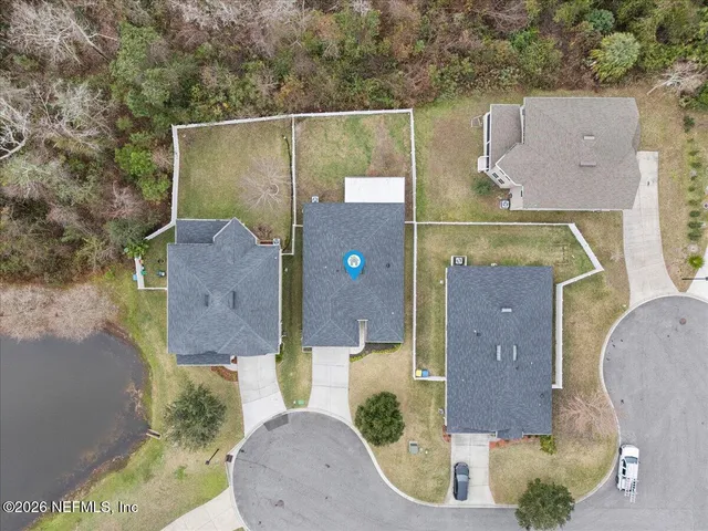 an aerial view of a house with pool and a yard