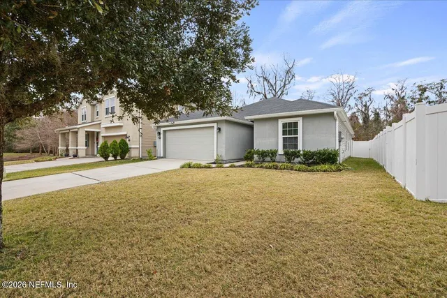 a front view of house with yard and trees in the background